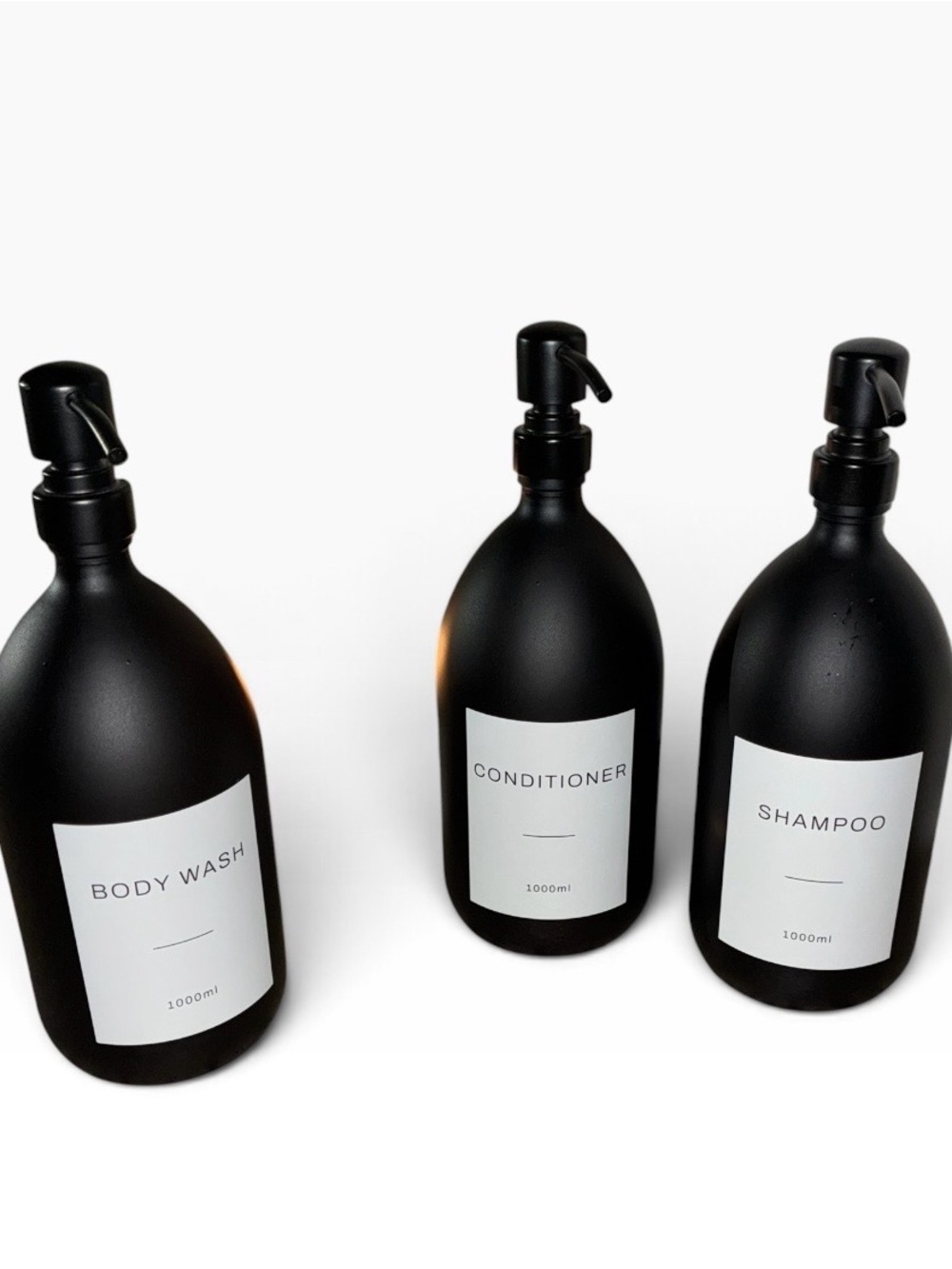 Three 1000ml matte black glass dispenser bottles with waterproof labels.
